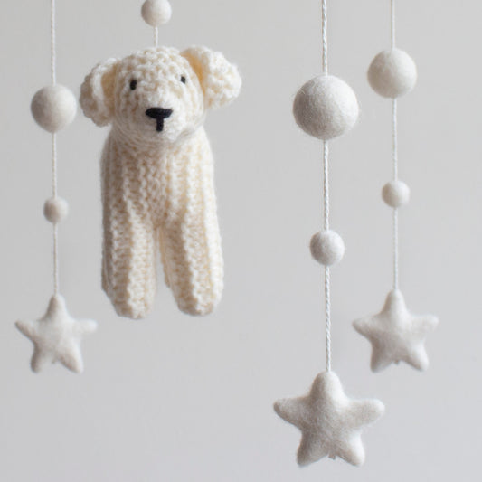 Close-up of a hand-knitted English cream golden retriever puppy amigurumi for a dog-themed nursery.