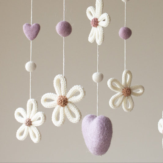 Close-up of knitted daisy petals and felted hearts