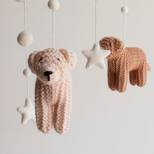 Close up of hand knitted wool dog hanging on a baby mobile. Perfect gft for dog-loving families