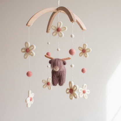 Artisan hand-knitted daisies with dusty rose centers and cream wool petals for a farm nursery theme.