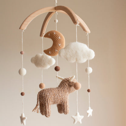 High-contrast white stars and dark highland cow elements designed to support infant visual stimulation.