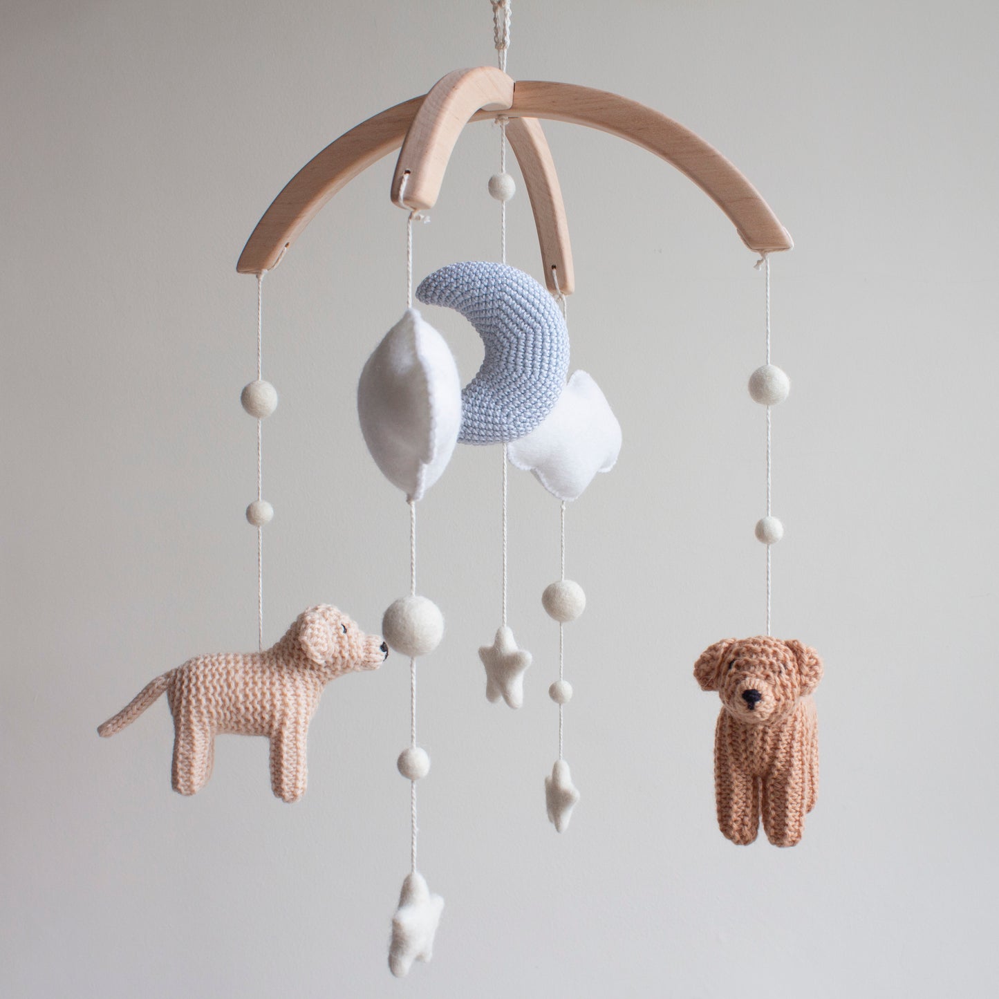 Baby mobile with knitted animals and stars on a wooden arch 
