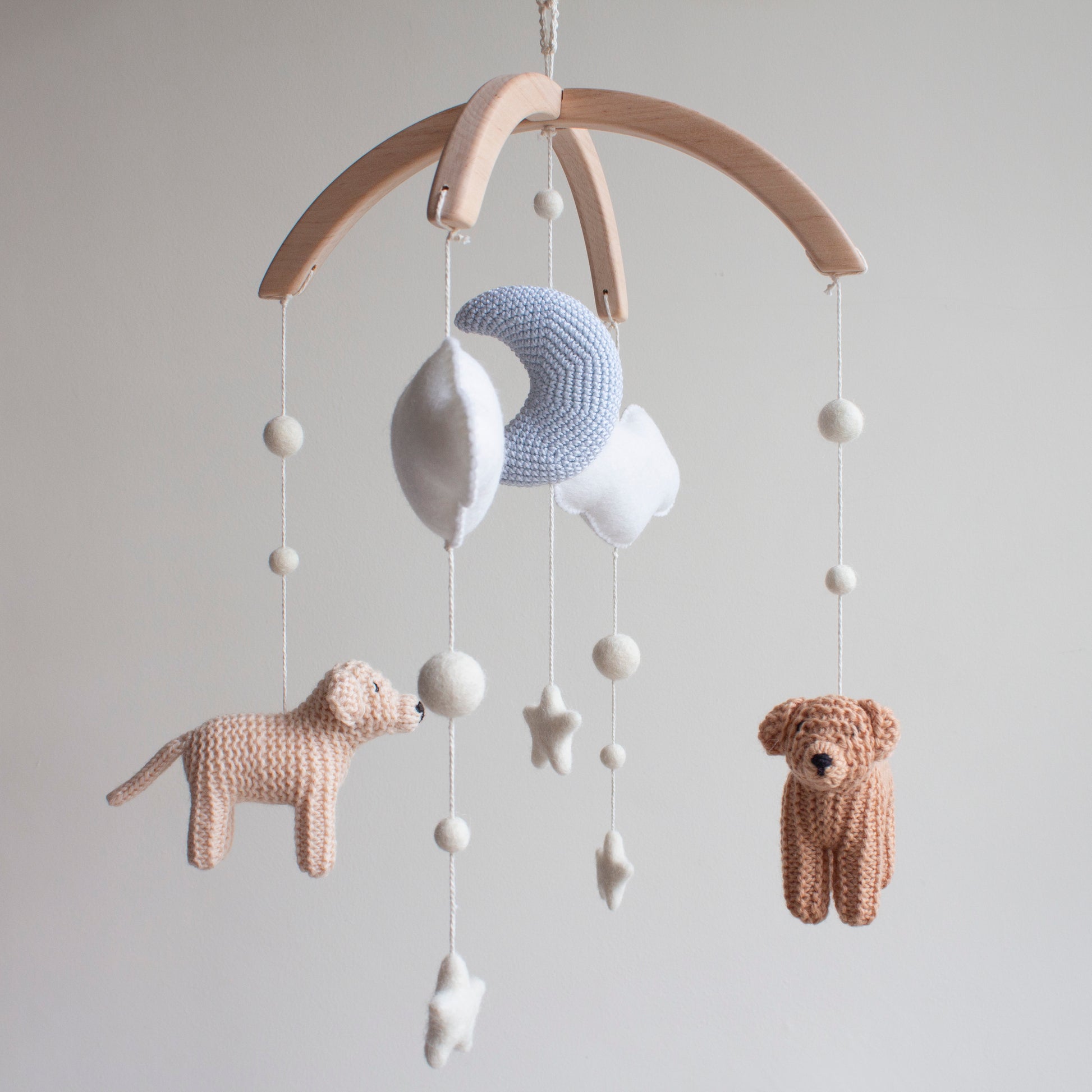 Baby mobile with knitted animals and stars on a wooden arch 