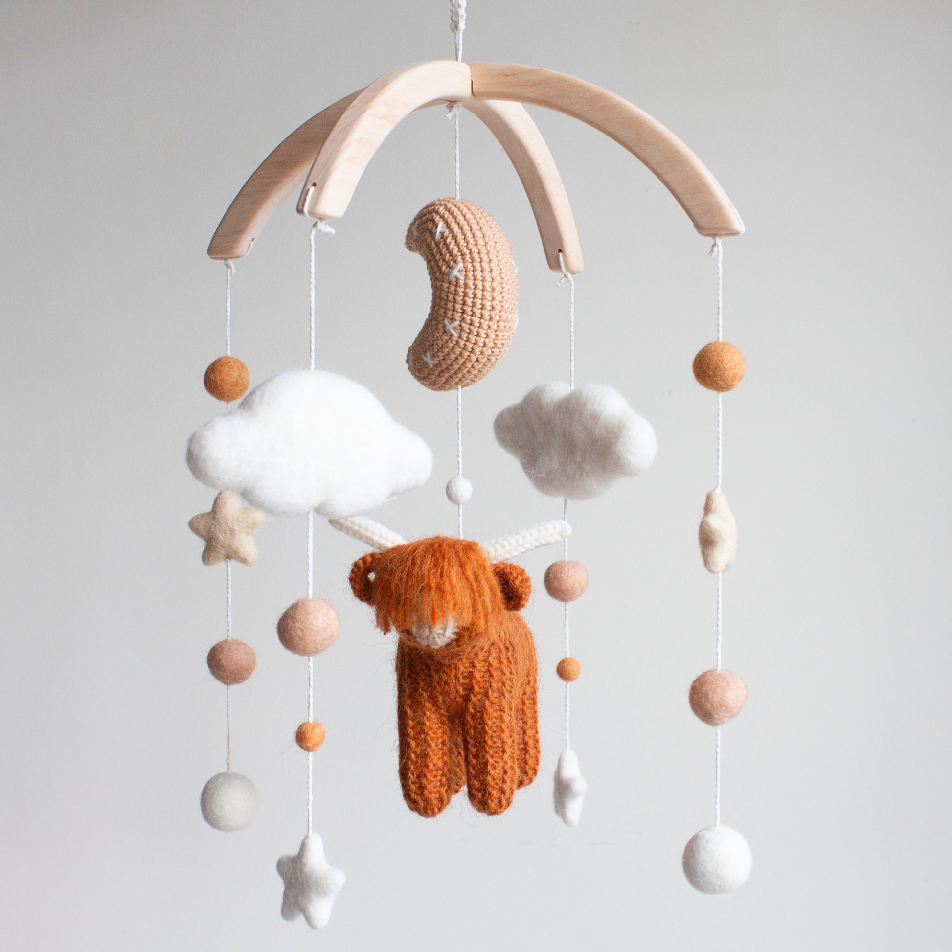 Highland Cow baby mobile with burnt orange cow, crochet moon, and clouds on wooden arch