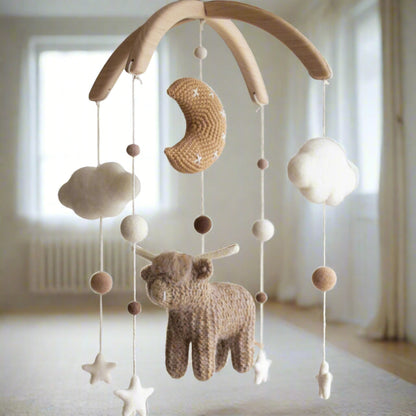 Rustic Western-themed nursery mobile hanging in a modern baby room above a wooden crib.