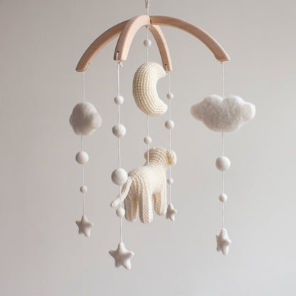 Crochet crescent moon and soft white stars on a golden retriever nursery mobile.