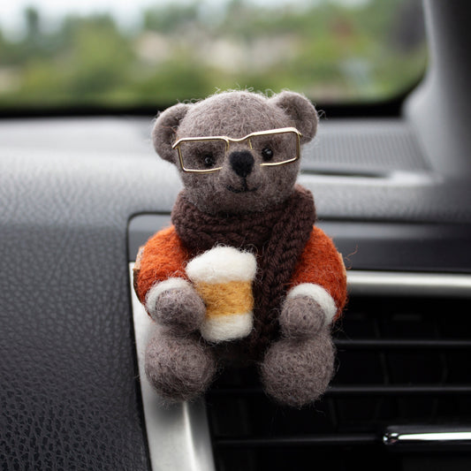 needle felted bear with glasses and a coffee cup attached to a car's air vent.