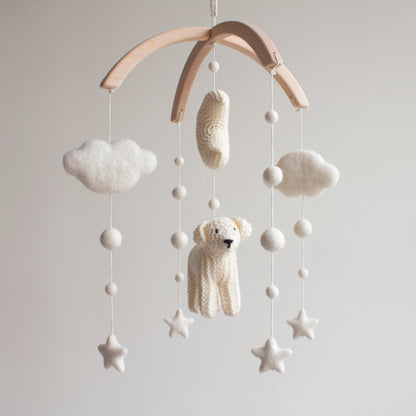 Neutral golden retriever nursery mobile hanging in a modern, Scandi-style baby room above a white crib.