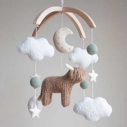 Close-up of a hand-knitted crochet highland cow with fuzzy texture and neutral brown yarn.