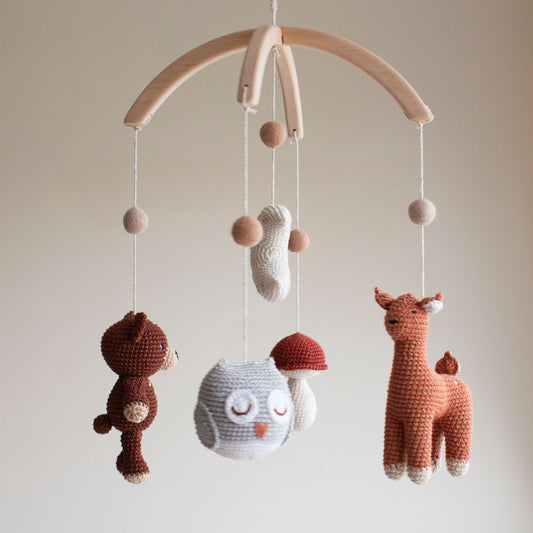 Woodland mobile showing high-contrast white and dark elements to support infant visual development.
