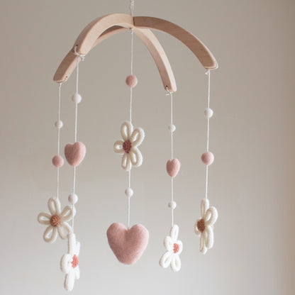 Untreated solid alder wood cross-arch hanger for a minimalist artisan baby mobile. Artisan daisy nursery mobile—a unique baby shower gift for a boho girl nursery.