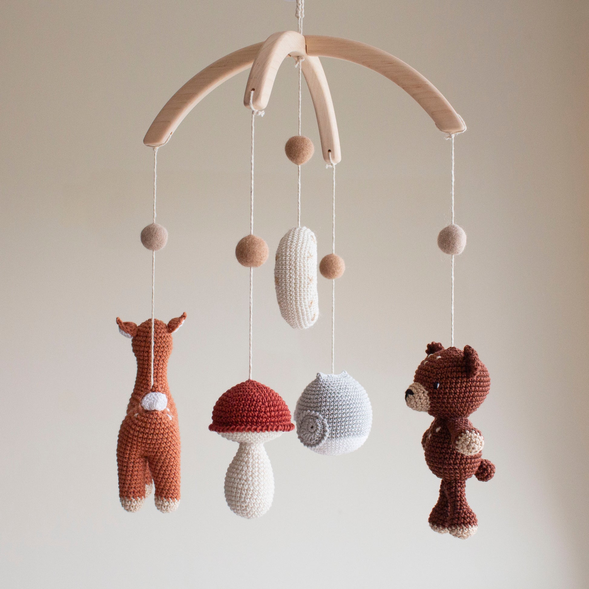 Detailed shot of a hand-knitted earthy brown bear amigurumi for a forest-themed baby room.