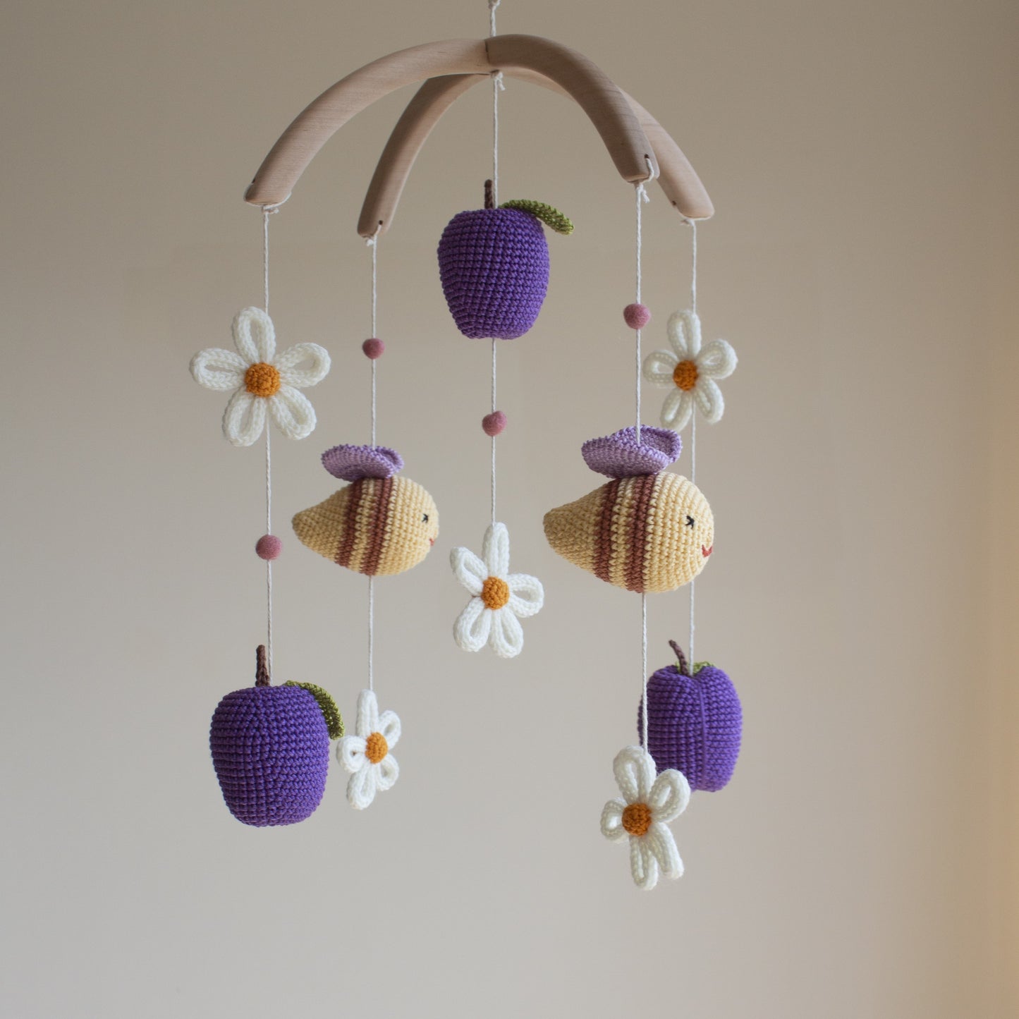 Bees and plums mobile showing high-contrast purple and white elements for infant visual stimulation.