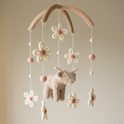 Artisan hand-knitted daisies with dusty rose centers and cream wool petals for a farm nursery theme.