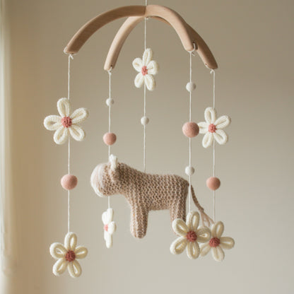 Smooth untreated solid alder wood cross-arch hanger for a minimalist nursery mobile. Macro view of 100% wool-mix yarn stitches on a handmade highland cow baby gift.